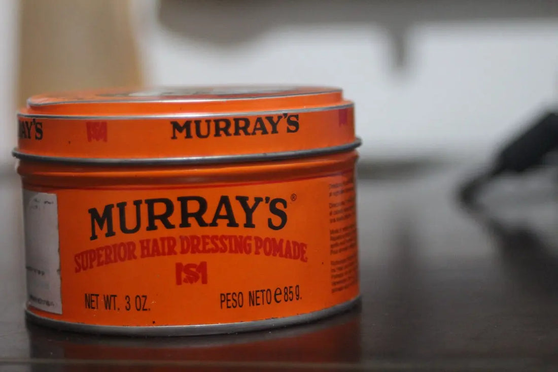 two tins of hair dressing sitting on a table
