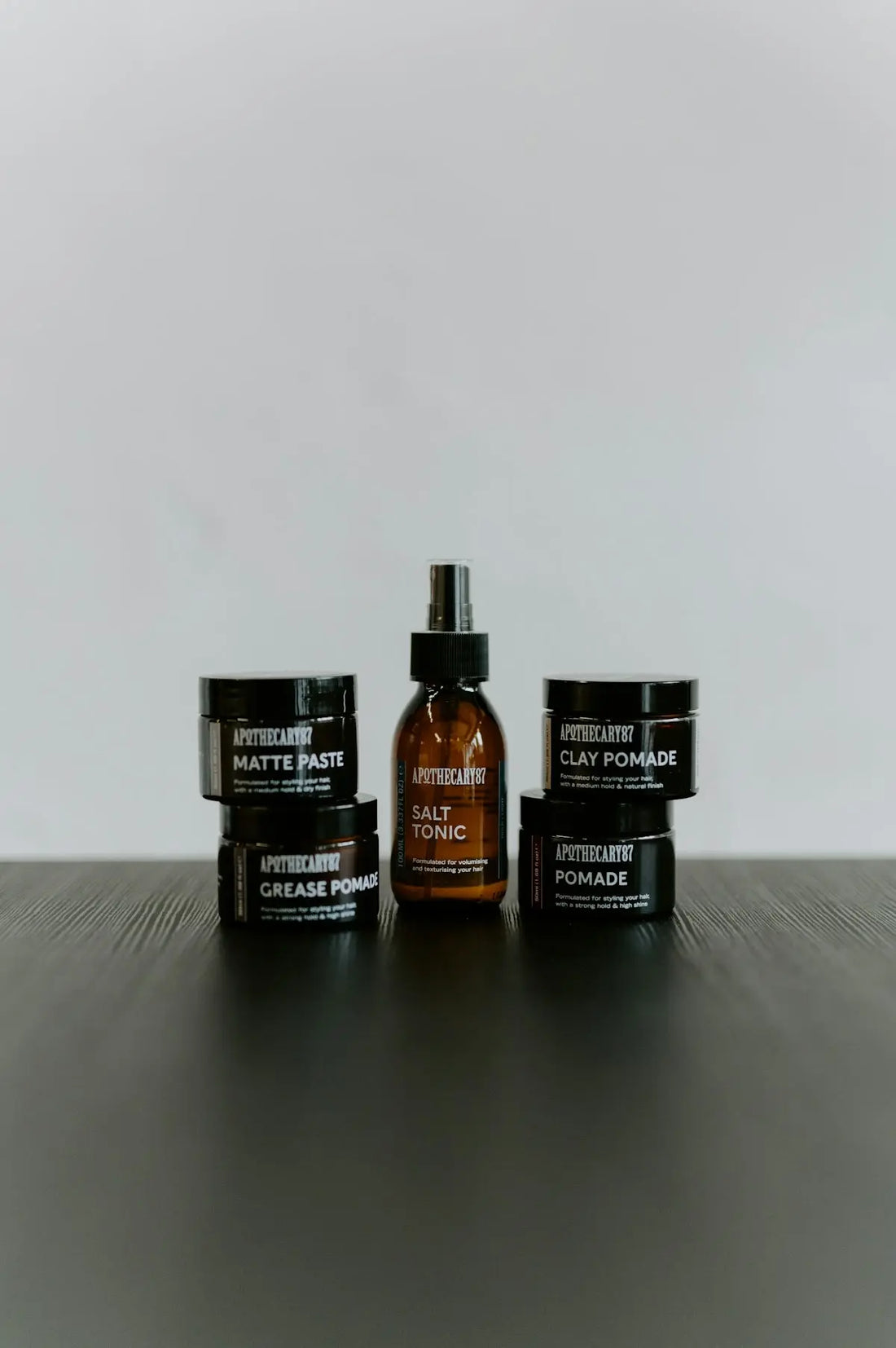 Hair styling products including pomade, paste, and tonic.