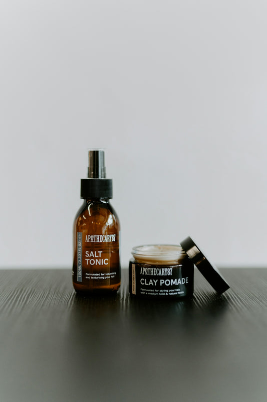 Two apothecary products, salt tonic spray and clay pomade.