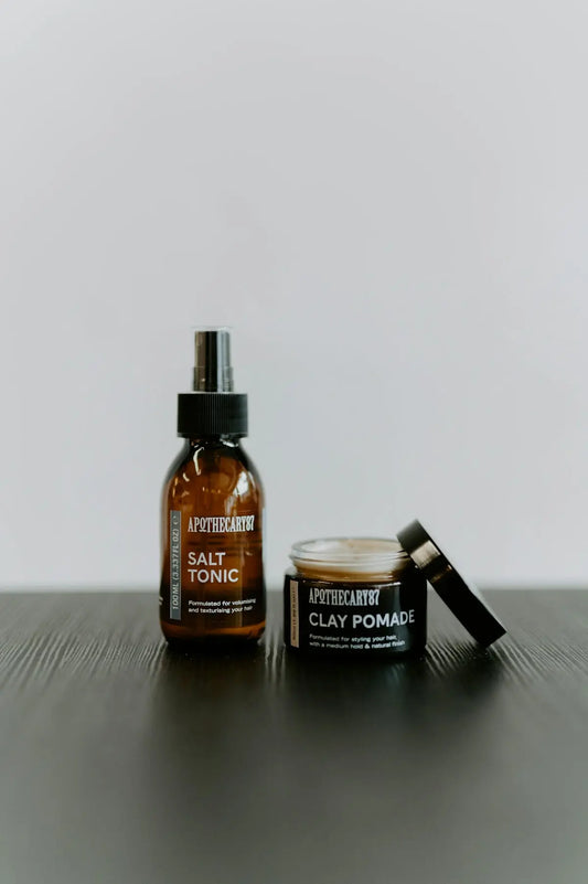 Two apothecary products, salt tonic spray and clay pomade.