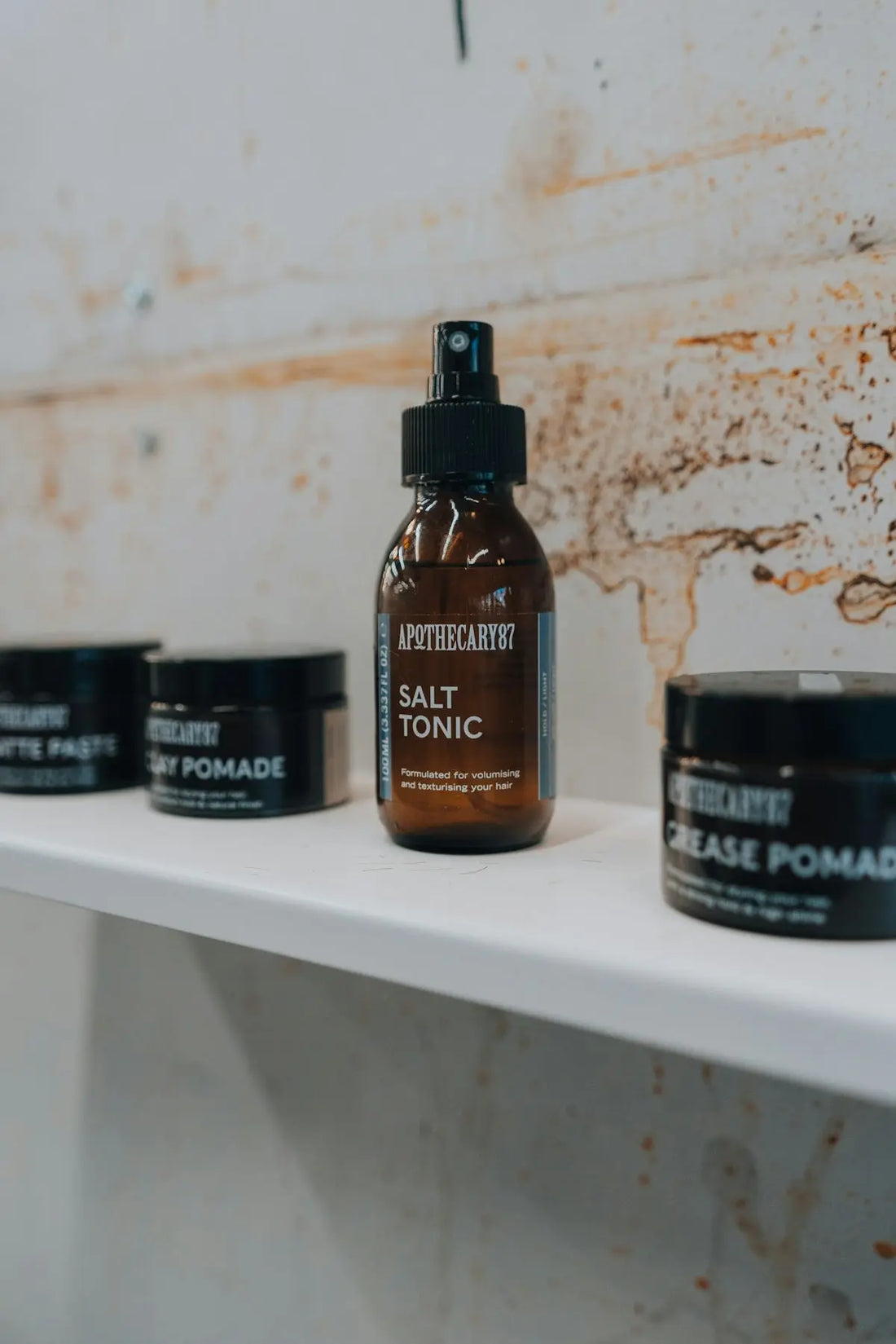 Apothecary salt tonic and pomades on a shelf.